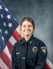 Portrait of Megan Klumpyan sitting in front of an American flag