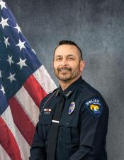 Portrait of Jeremy Stodola sitting in front of an American flag