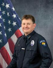 Portrait of Cale Beyer sitting in front of an American flag