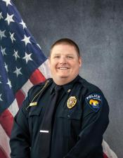 Portrait of Matthew Lutze sitting in front of an American flag