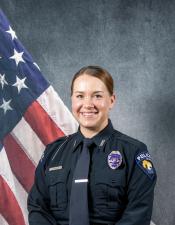Portrait of Jessica Rogers sitting in front of an American flag