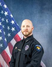 Portrait of Justin Jackson sitting in front of an American flag