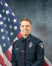 Portrait of Daniel Stonebraker sitting in front of an American flag