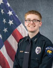 Portrait of Brennon Daley sitting in front of an American flag