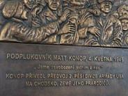 A bronze plaque of a rendering of Lt. Col. Matt Konop hoisted on shoulders photo