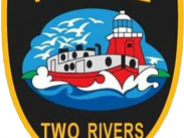 Police badge. Black badge with picture of boat in front of a lighthouse. Text reads: "Police Two Rivers"