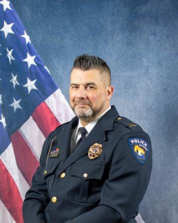 Portrait of Andrew Raatz sitting in front of an American flag