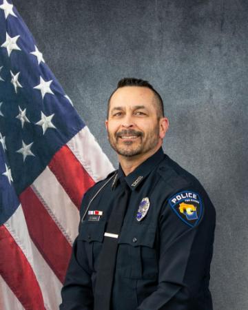 Portrait of Jeremy Stodola sitting in front of an American flag