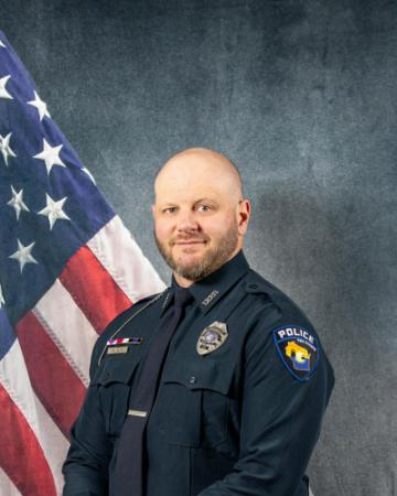 Portrait of Andrew Lade sitting in front of an American flag