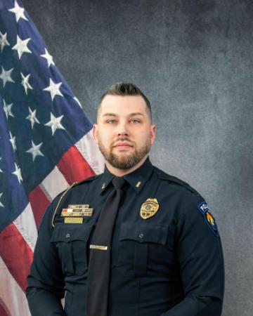 Portrait of Jacob Schweigl sitting in front of an American flag