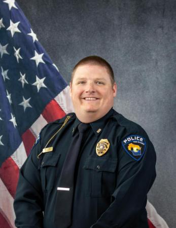 Portrait of Matthew Lutze sitting in front of an American flag