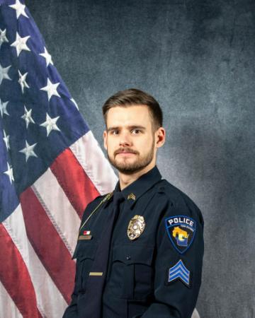 Portrait of Leander Menn sitting in front of an American flag