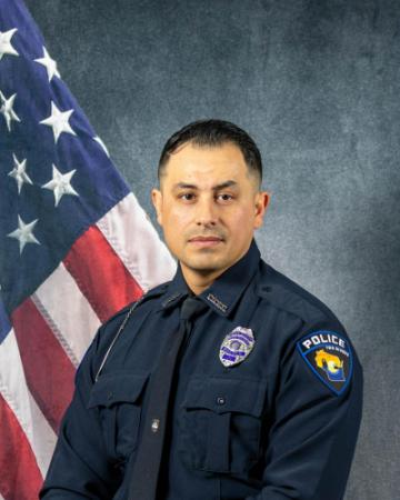 Portrait of Santos Torres-Zapien sitting in front of an American flag