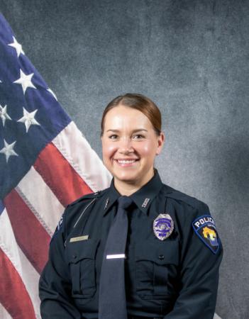 Portrait of Jessica Rogers sitting in front of an American flag