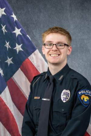 Portrait of Brennon Daley sitting in front of an American flag