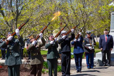 Veterans in uniform fire a salute.
