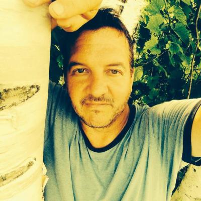 Man leaning on a birch tree.