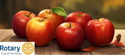 Red apples on a wooden table with Rotary logo in lower left.