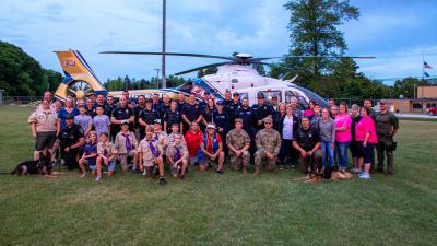 First responders and other volunteers standing in front of helicopter.