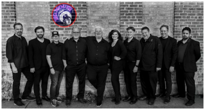 B/W image of the 10 members of the band, all dressed in black.