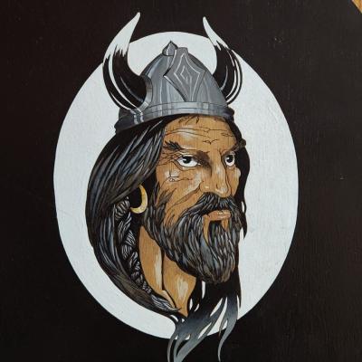 Viking with beard, long hair, earring and hat with horns.