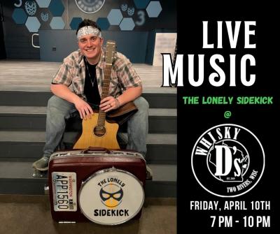 Smiling man sitting on steps holding guitar.