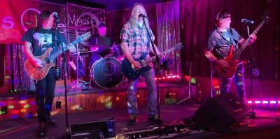 Four members of Minus One playing onstage.