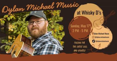 Man in ballcap holding guitar.