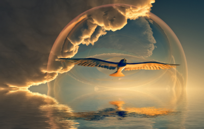 A sea bird flying above water and amongst lovely clouds.