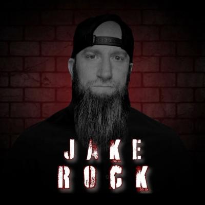 Solemn-looking bearded man wearing backward ballcap.