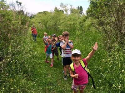 Happy kids traversing a path single-file.