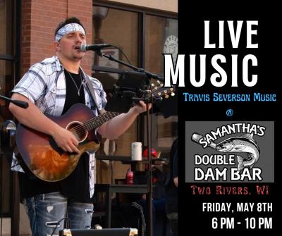 Man onstage outdoors singing and strumming guitar.
