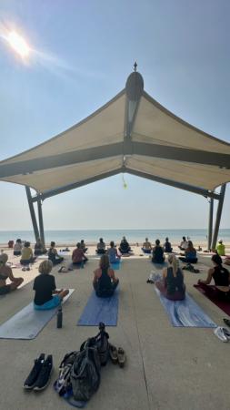 Folks sitting on yoga mats at Neshotah Beach.