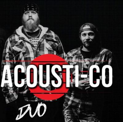 Two standing men, one somber, one smiling, clad in flannel.