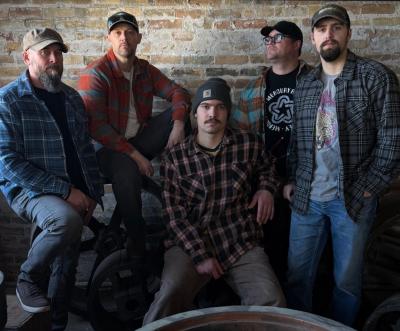 Five somber-looking men in flannel and ball caps.