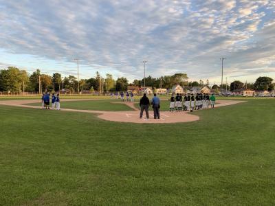 Baseball players on Walsh Field with a lovely early evening sky in the background.