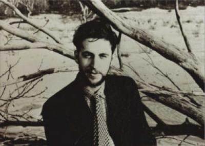 A somewhat smiling man (Lester Bentley) outdoors in a b/w photo.