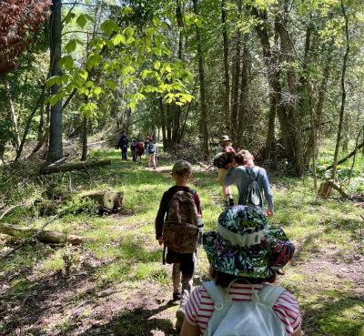 Several kids heading into the woods.