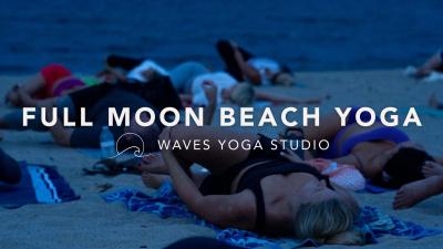 Adults practicing yoga on the beach.