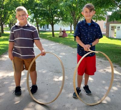 Two boys with old-fashioned hoops at Pinecrest Village.