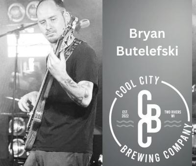 B/W image of man playing guitar onstage.