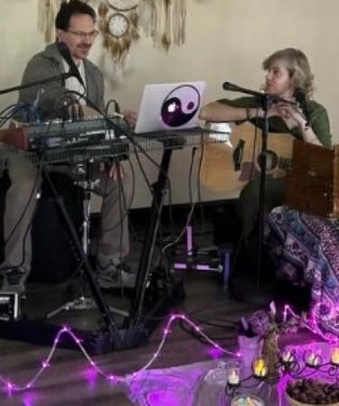 Man at keyboard and woman holding guitar.
