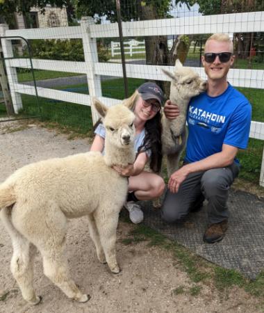 Man and woman with alpaca babies.