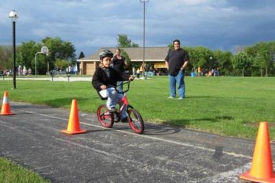 Child riding bike around obstacles.