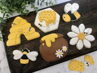 Cookies decorated as bees, flowers and bee hives.