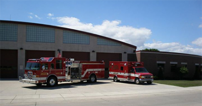 Two firetrucks parked in front of a garage