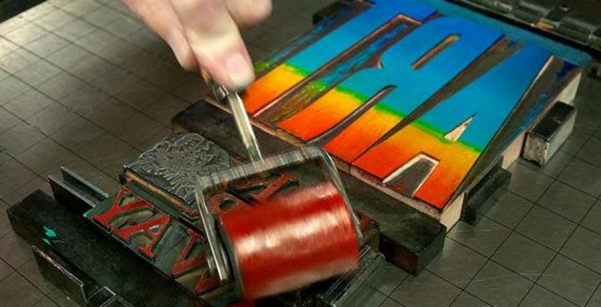 A large stamp being covered in ink via a large roller