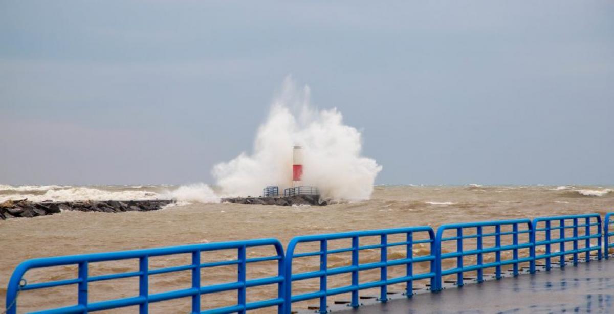 A large wave on Lake Michigan splashing over a structure 