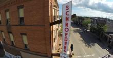 An aerial view of the Schroeders sign attached to a red brick building